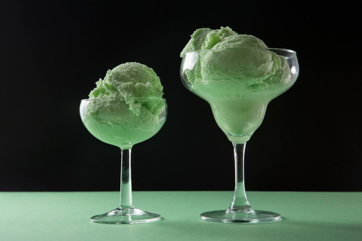 Two elegant glass bowls filled with vibrant green ice cream 